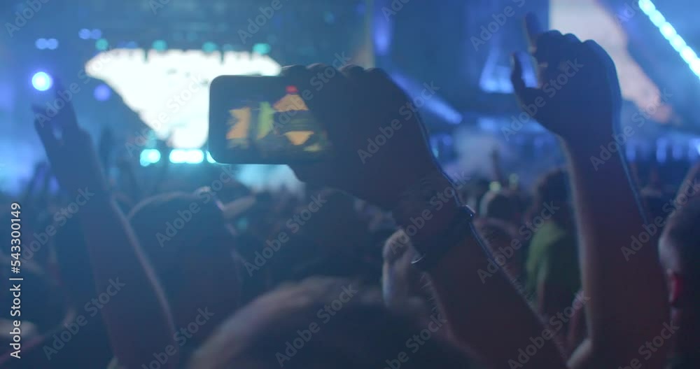 Hand holding phone in video function at dance floor party. The video blogger makes a broadcast using the LTE network, mobile Internet.