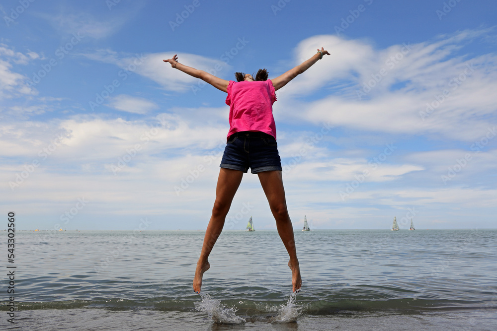 happy girl jumping and rejoicing for joy by the sea happy girl jumping and rejoicing for joy by the sea