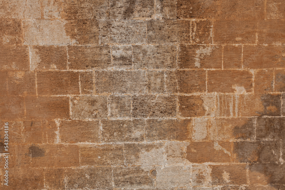 An old stone wall background. The worn stone wall over time. An old stone wall background. The worn stone wall over time.