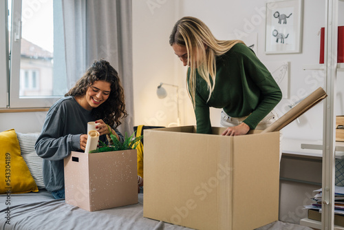 Fotografie european female students unpacking in dorm room