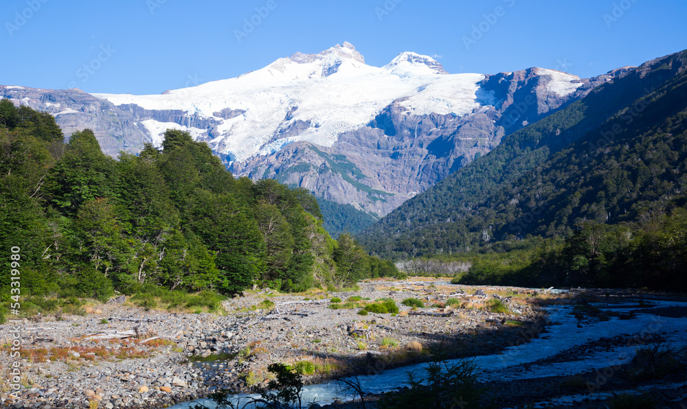 Cauquenes River bank and view of mountain (volcano) Tronador and glacier on sunny day. Andes, Patagonia, Argentina