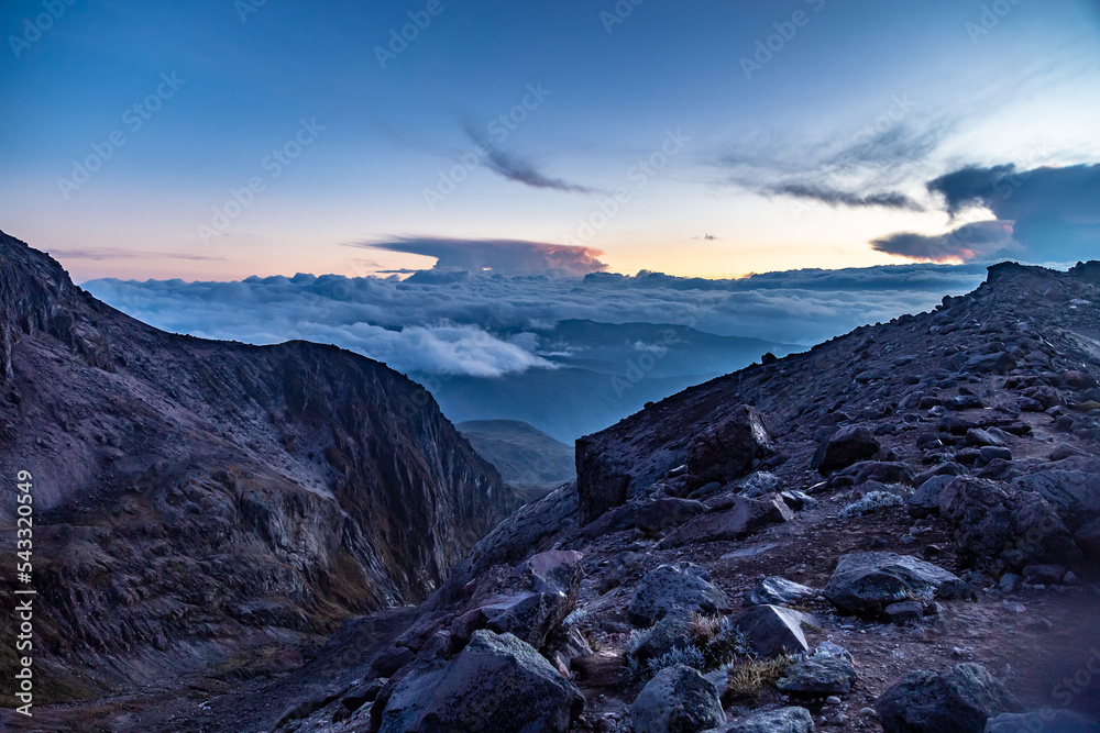 Sunset between clouds and rocks of the Cayambe volcano