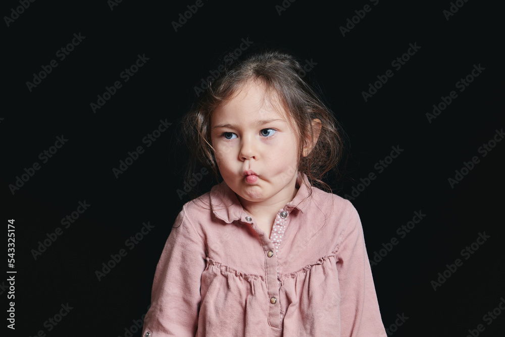pretty girl making expressive faces in the studio against a black background pretty girl making expressive faces in the studio against a black background