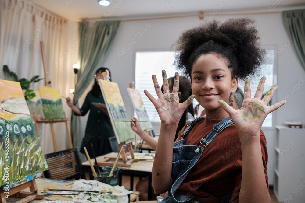 African American girl shows her hand messed up with acrylic colors