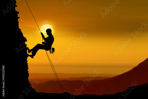 Silhouette of a rock climber over beautiful sunset © mbolina