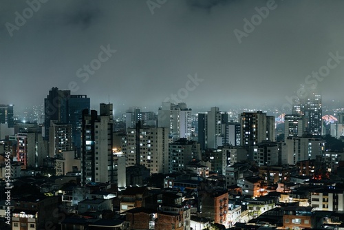 Beautiful cityscape of Bucaramanga with glowing building and street lights under a misty gray sky photo