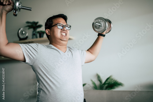 Funny fat man workout with dummbell photo