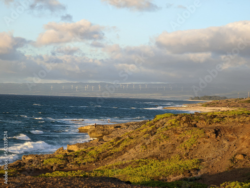 This is the view from the western point of O'ahu looking back east. I was in Ka'Ena Point Nature reserve and was looking bake east over the coast and saw the windmills lighted in the setting sun. 