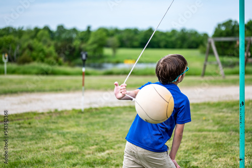 Tetherball being hit and roped in a game with a young boy. 