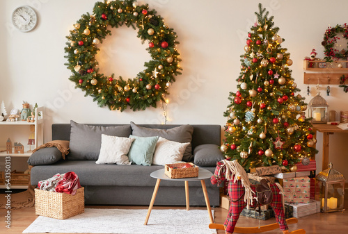 Living room interior. Christmas tree and wreath. New Year celebration. Vacation rentals. Winter holidays and vacations