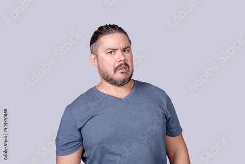 An unconvinced man puzzled and miffed upon hearing hearsay. Showing disbelief and skepticism. Suspecting a hoax. Isolated on a gray background. photo