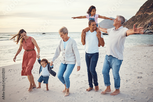 Happy big family, vacation and beach walk for quality bonding time together in the outdoors. Mother, father and grandparents with children playing with smile in happiness for family trip by the ocean photo