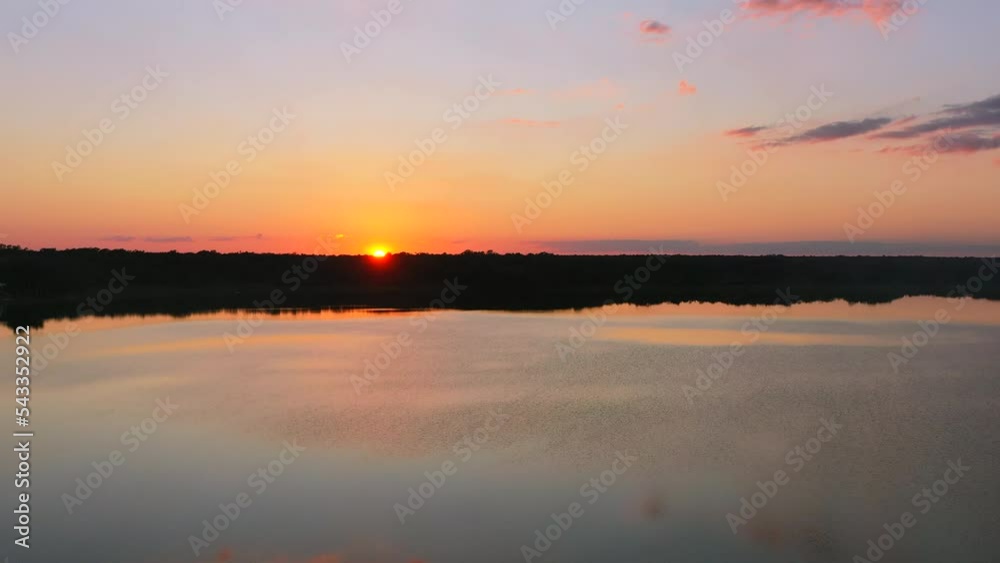 aerial of beautiful fire red sunset setting below horizon surrounded by tropical water at Laguna Coba town in Mexico with purple sky aerial of beautiful fire red sunset setting below horizon surrounded by tropical water at Laguna Coba town in Mexico with purple sky