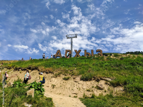 Arkhyz, Karachay-Cherkessia, Russia - August 21, 2022: People climb the mountain to the installation called Arkhyz. Translation: Arkhyz