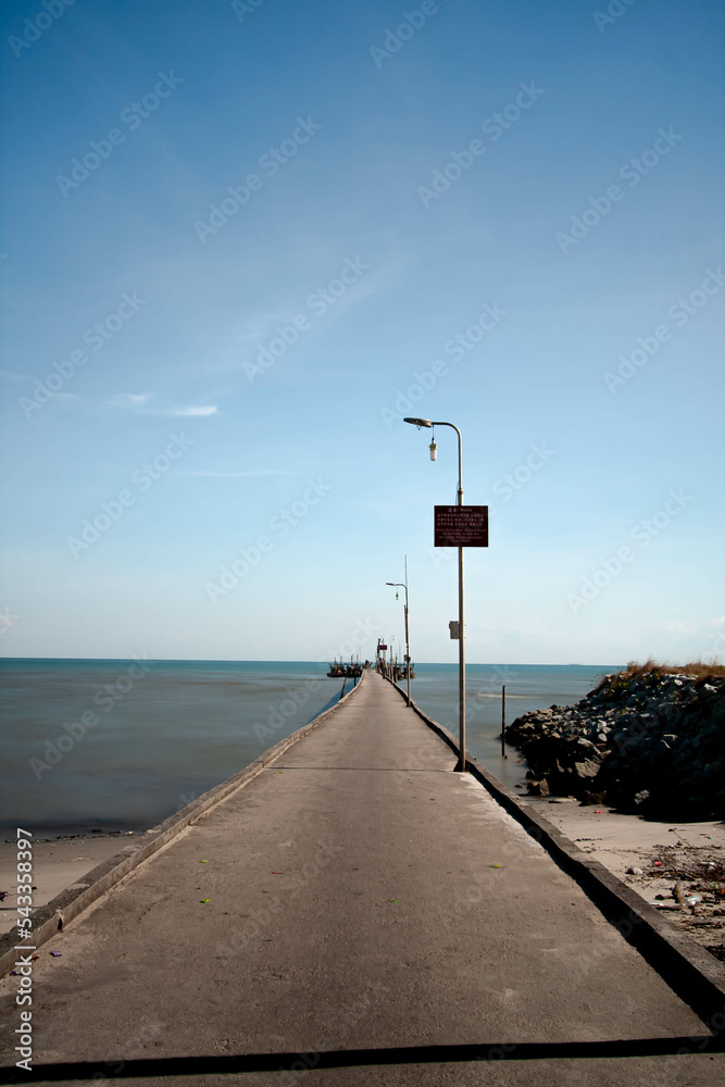 Concrete pier or jetty and sea at blue sky.