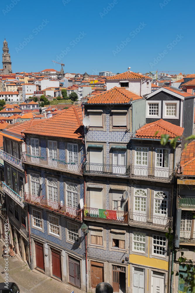 Tall buildings with colourful tiled facade walls in a Oporto skyline, in Portugal on a blue sunny sky