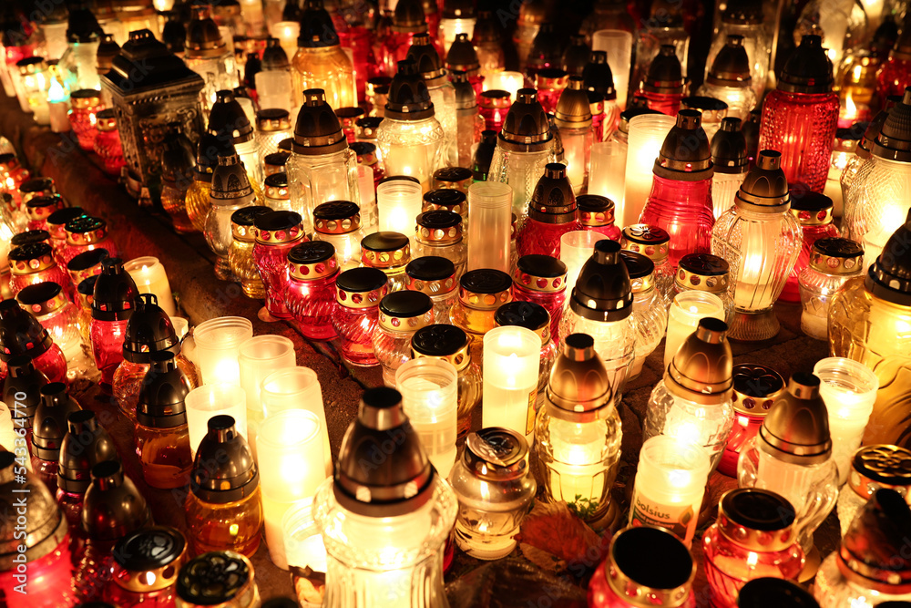Znicze na grobie osoby bliskiej świeci podczas święta zmarłych wieczorem. Wrocławski cmentarz.  - obrazy, fototapety, plakaty 