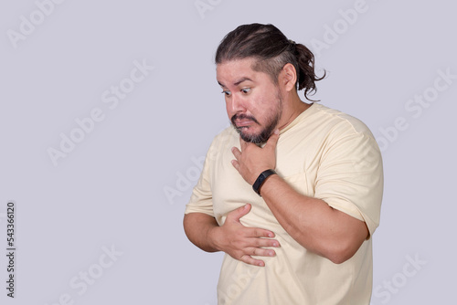 A nauseated man has a gag reflex. Having the urge to vomit. Scene isolated on a gray background. photo