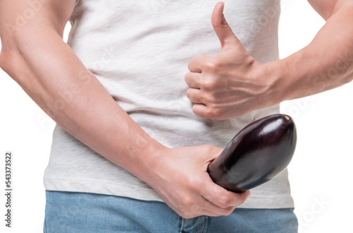 Guy crop view giving thumb holding eggplant at crotch level imitating large penis isolated on white photo