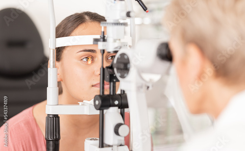 Woman at eye lens test, healthcare for vision by optician for contact lens and focus with laser medical tool. Eyesight, expert optometrist consulting glaucoma patients insurance and visual zoom