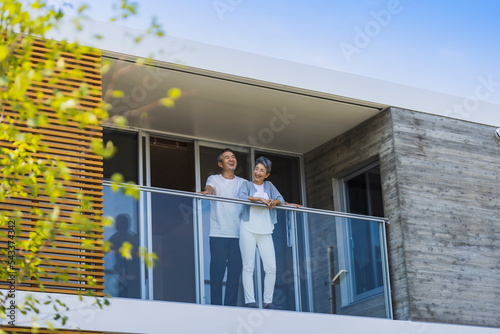 ベランダから外を眺める日本人シニア夫婦