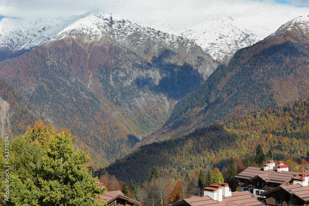 Tourist ski village on the background of colorful wooded mountains in autumn.