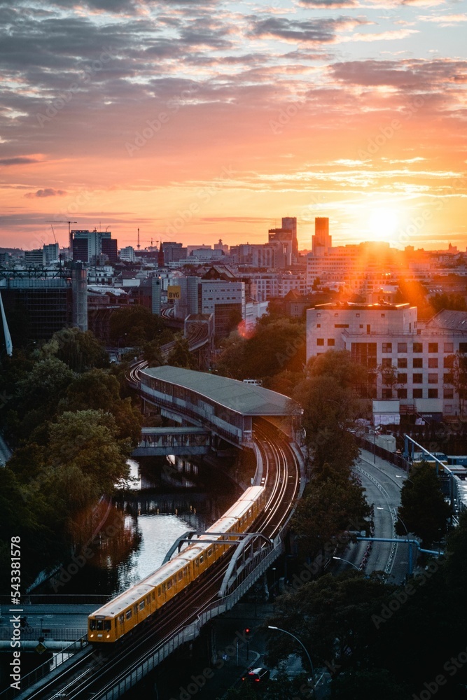 Naklejka premium Aerial view of train on railway surrounded by buildings in Berlin during sunset