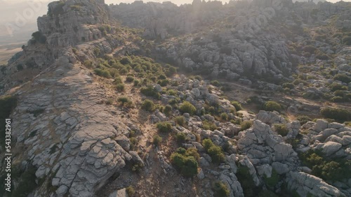 Aerial drone forward moving shot over eroded rocky formation mountain tops in Torcal de Antequera seen from above in Spain during evening time. photo