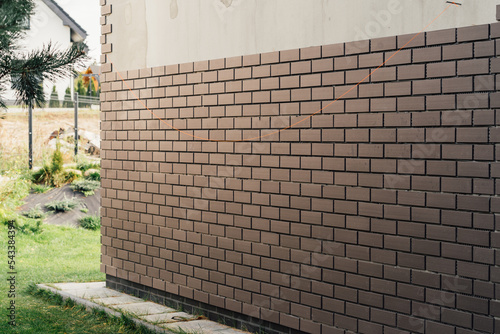 laying clinker tile on the facade of the house