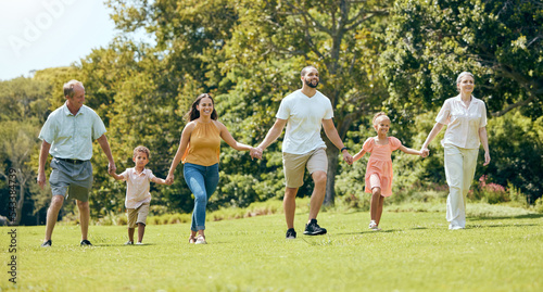 Grandparents, parents and kids walking in the park, happy .and bonding together outdoor. Family, holding hands and fun being loving, happiness and adventure on vacation, spend quality time and love.