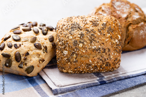 Gold rustic crusty loaves of bread and buns on wooden background. Still life captured from above top view, flat lay.