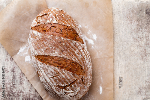 Gold rustic crusty loaves of bread and buns on wooden background. Still life captured from above top view, flat lay.