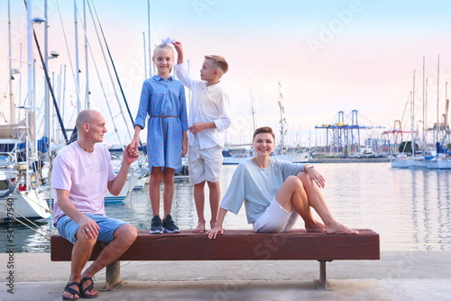 mom, dad, daughter and son happy family on sea marina background © ulianna19970