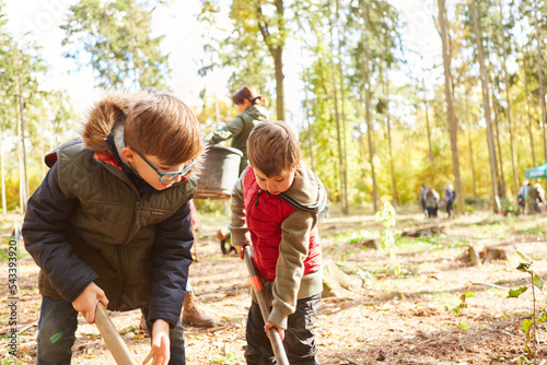 Zwei Jungen helfen bei der Aufforstung Aktion im Wald