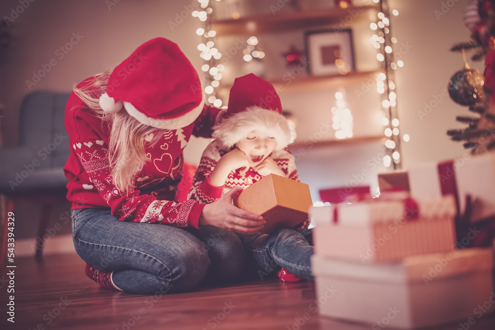 © candy1812 - Mother and son indoors looking inside of gift box in Christmas eve. © candy1812 - Mother and son indoors looking inside of gift box in Christmas eve.