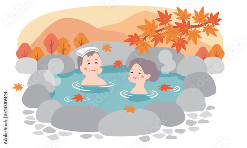 秋の露天風呂に入るシニア夫婦