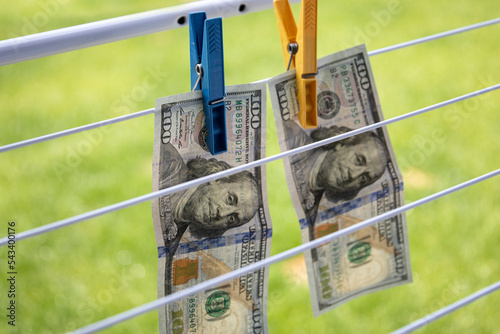 American dollars are hanging to dry outside. Money laundering. Two banknotes denomination one hundred dollars.