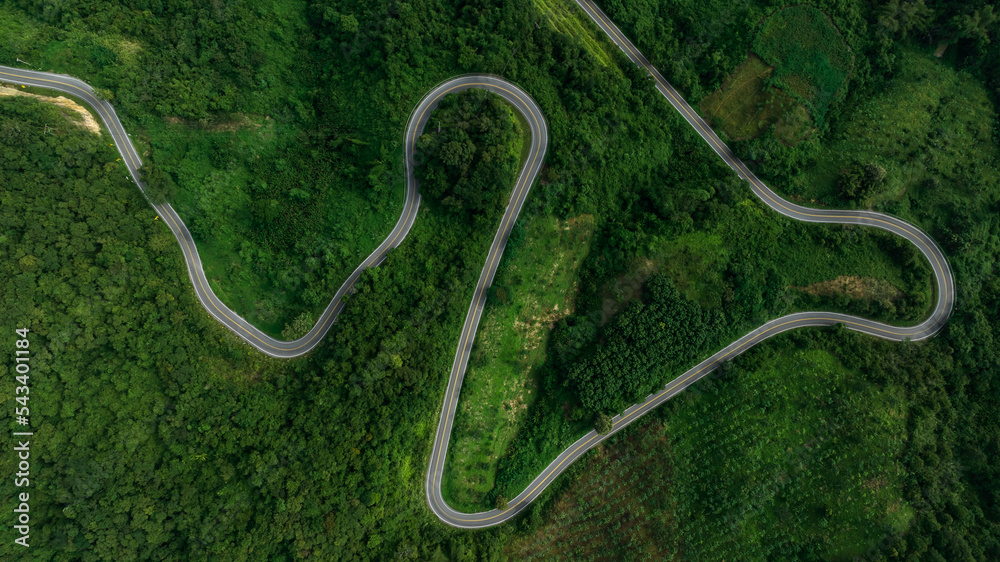 beautyfull curve road on green forest in the rain season background, rural routes connecting cities in the north of thailand