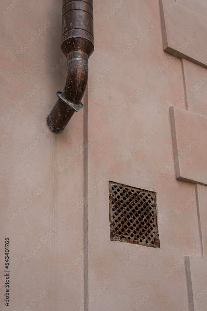 Old light orange wall with metal window and downpipe Old light orange wall with metal window and downpipe