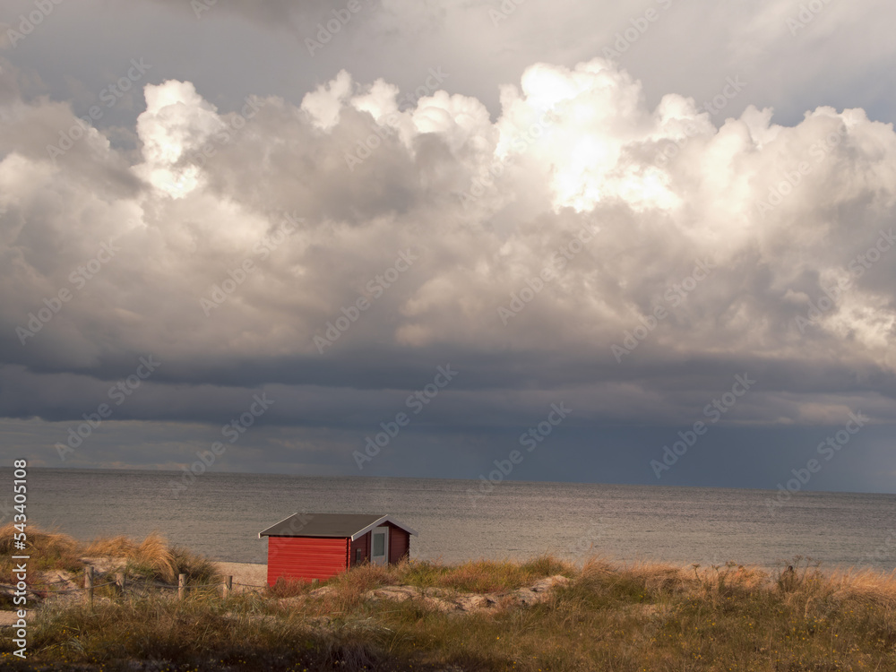 einsame Strandhuette an der Ostseeküste unter großen Wolken am Abend 