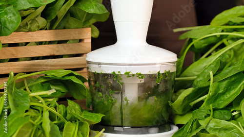 Spinach smoothie. The process of making smoothies in a blender from green spinach leaves. Concept of healthy eating, fitness food menu, healthy lifestyle, diet slow motion close-up
