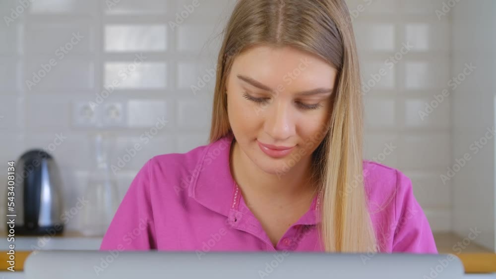 Beautiful blond girl working on laptop at home. Portrait of pretty Ukrainian female using notebook computer Beautiful blond girl working on laptop at home. Portrait of pretty Ukrainian female using notebook computer