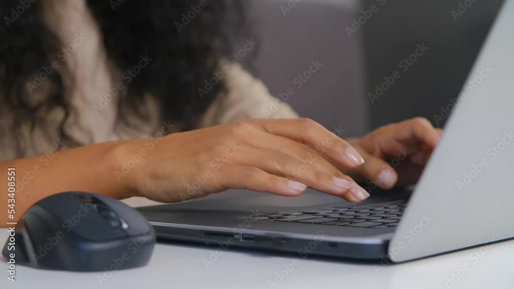 Black woman typing text on laptop keyboard. Dark skinned female person working on modern notebook computer