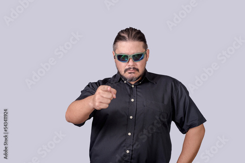 A tough looking bodyguard or security escort calling out someone. Poiting with his finger. Copyspace on the left.