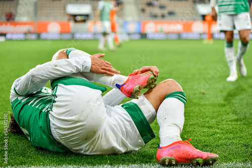 The injured footballer lies on the pitch.