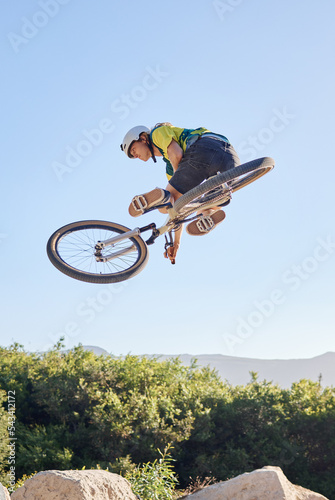 Bike, extreme sport and outdoor fitness, man does dangerous stunt, sports motivation and training in nature. Exercise, athlete with mountain bike, risk and active with energy and jump over rocks.