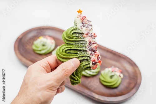 Person's hand holding Christmas tree cookie