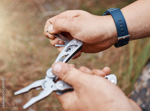 Man hands use multi purpose knife for camping, outdoor survival and adventure in park, woods and scouts hiking. Sharp pocket tool, practical accessory and handy steel utility equipment for hiker guy