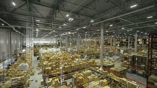Top view of manufacture warehouse with logistics numbers holograph over cardboard boxes