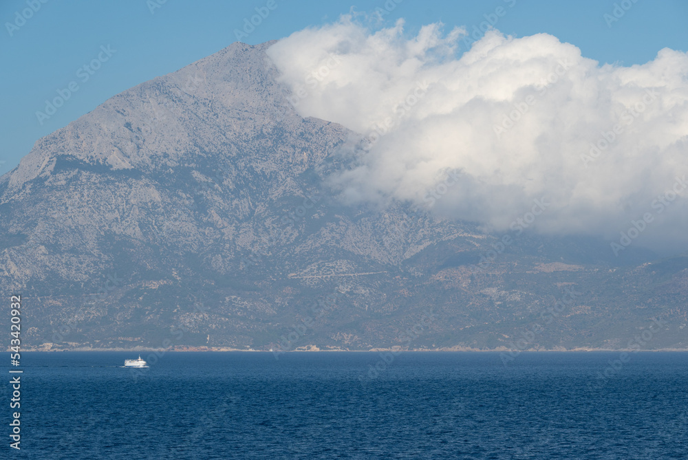 View of the Aegean Island of Samos from the sea with white clouds over the mountains